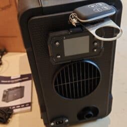 Kroak TB2 diesel parking heater 8kW: Unboxing, test & possible applications 8 A portable black and blue kroak TB2 device with a control panel, a vent and a remote control attached to a key ring stands on a light-colored floor. Instructions for use and cables are nearby. www.commaik.de
