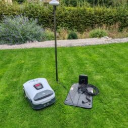 Anthbot Genie robotic lawnmower in test: Perfect lawn mowing without cables? 21 A robotic lawnmower, such as the Anthbot Genie 600, stands on the grass next to its charging station and a high mast with a sensor. In addition to automatic navigation, manual control via Bluetooth is also possible for targeted reworking via app. www.commaik.de
