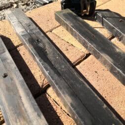 a black piece of wood on a brick surface