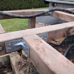 a wood frame with metal bolts and a hose