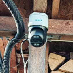 The best Reolink 4k PTZ surveillance cameras in comparison: 823S2 vs 823S1 vs TrackMix vs TrackFlex in test 19 A 4K PTZ surveillance camera from Reolink is mounted on a wooden beam under a roof, near which black cables and stacked firewood can be seen. www.commaik.de