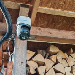 The best Reolink 4k PTZ surveillance cameras in comparison: 823S2 vs 823S1 vs TrackMix vs TrackFlex in test 21 A 4K PTZ surveillance camera from Reolink is mounted on a wooden beam under the roof, with stacked firewood underneath and electrical cables running along the structure. Another small, white device is mounted nearby. www.commaik.de