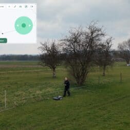 Lymow One Plus in test: RTK robot mower for large areas & difficult terrain 29 A person stands next to a Lymow One Plus robotic lawnmower in a grassy field with trees and fences. The screen shows the user interface for setting zones in the mower's control app when it is cloudy. www.commaik.de