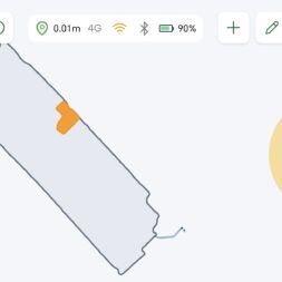 Lymow One Plus in test: RTK robot mower for large areas & difficult terrain 53 A digital map interface on the Lymow One Plus shows an area outlined in gray with an orange segment. Two large circular control elements with arrows are located on the sides. Status icons show location accuracy, 4G, Wi-Fi and 90 % battery. www.commaik.de