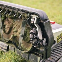 Lymow One Plus in test: RTK robot mower for large areas & difficult terrain 20 Close-up of the underside of a Lymow One Plus robotic lawnmower. You can see blades and grass clippings sticking to the mechanism while the mower is standing on a meadow. www.commaik.de