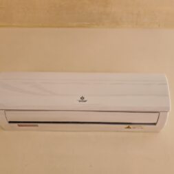 Installing Air Conditioning Yourself in an Older Building – Heating and Cooling in Practice 5 A wall-mounted split-system air conditioner installed near the ceiling on a beige wall. www.commaik.de