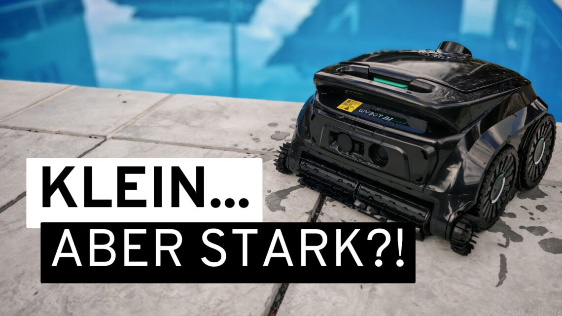 Pool 1 Ein kleiner schwarzer WYBOT B1 Poolroboter steht am Rand eines Schwimmbeckens. Der deutsche Text „KLEIN… ABER STARK?!” ist in fetten weißen und schwarzen Buchstaben eingeblendet und deutet auf einen bevorstehenden Test seiner beeindruckenden Reinigungsfähigkeiten hin. www.commaik.de