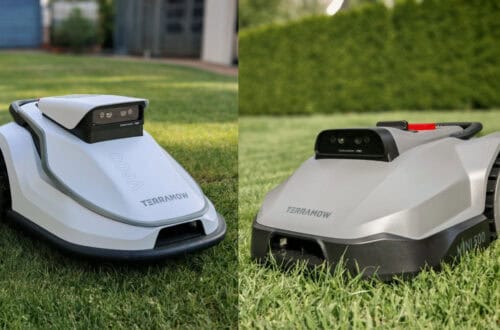 TerraMow V1000, V600, and Mini 500 Review: Robotic Lawn Mowers Without RTK and Lidar? 14 Two robotic mowers, the TerraMow V600 and the V500, are sitting on the lawn; cameras are mounted on their sleek gray bodies and wheels. The word “TERRAMOW” is clearly visible on both of them. In the background, you can see a hedge and a building—the perfect setting for an outdoor test. www.commaik.de