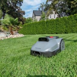 TerraMow V1000, V600, and Mini 500 Review: Robotic Lawn Mowers Without RTK and Lidar? 27 On a sunny day, a gray robotic mower—the Terramow V1000—efficiently mows a green, well-manicured lawn in the backyard near trees, a rock garden, and a tall hedge—an ideal testing environment for robotic mowers. www.commaik.de