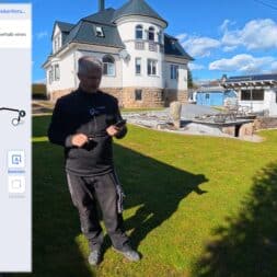 ECOVACS GOAT O1200 LiDAR PRO Review: Perfect Edge Mowing Without Any Touch-Ups? 19 A man is standing on a lawn with a smartphone, setting a route for an Ecovacs Goat robot, while a modern house with white walls and a dark roof can be seen in the background. On the left is a map screen showing a plotted route. www.commaik.de