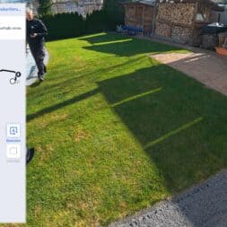 ECOVACS GOAT O1200 LiDAR PRO Review: Perfect Edge Mowing Without Any Touch-Ups? 20 A person is walking on a sunny lawn near a shed, while the screen shows the ECOVACS GOAT mapping app tracing a boundary line on the map of the garden. www.commaik.de